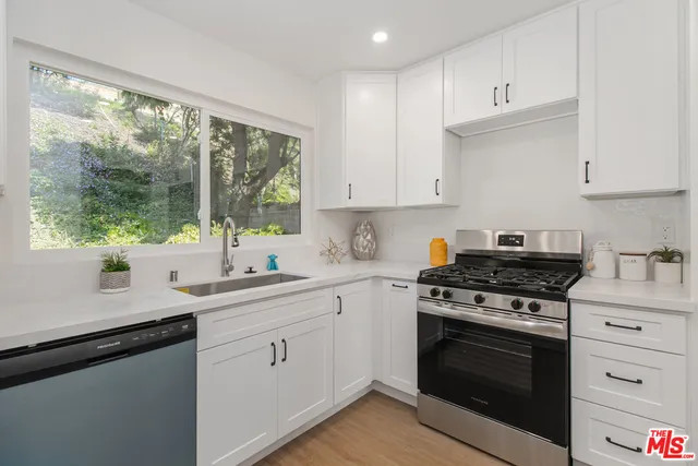 a kitchen with a stove a sink and a window