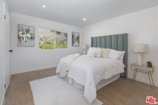 a bedroom with a bed and a painting on the wall