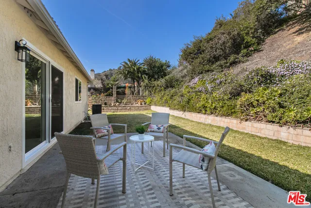 a view of chairs and deck in the backyard