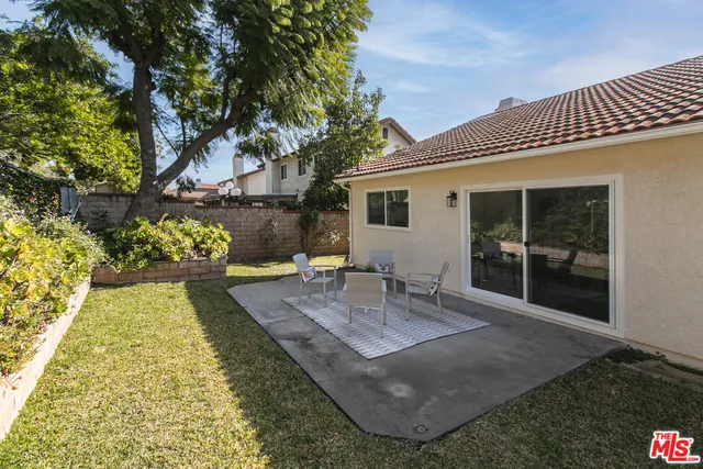 a view of a house with backyard and sitting area