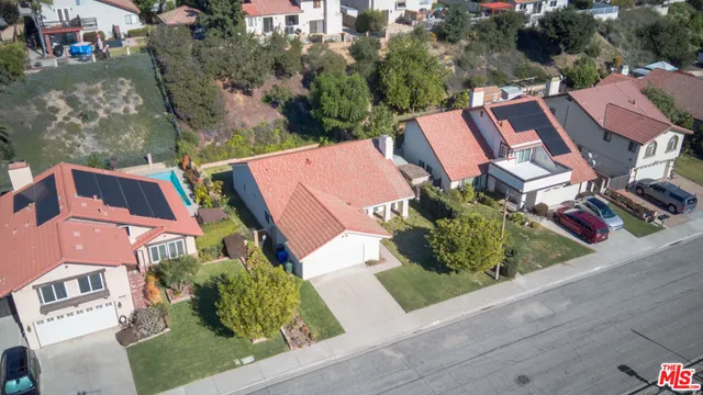 an aerial view of a house with garden space and street view