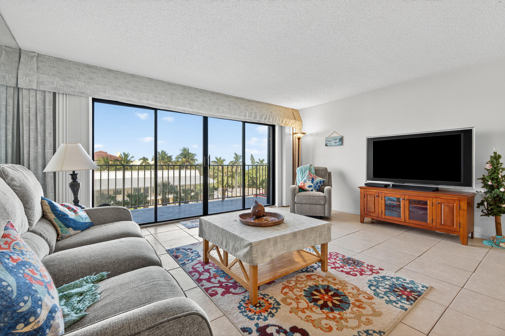 801 South Ocean Drive, Unit 404 Fort Pierce, FL 34949 - Photo 13 of 37 a living room with furniture a flat screen tv and a floor to ceiling window