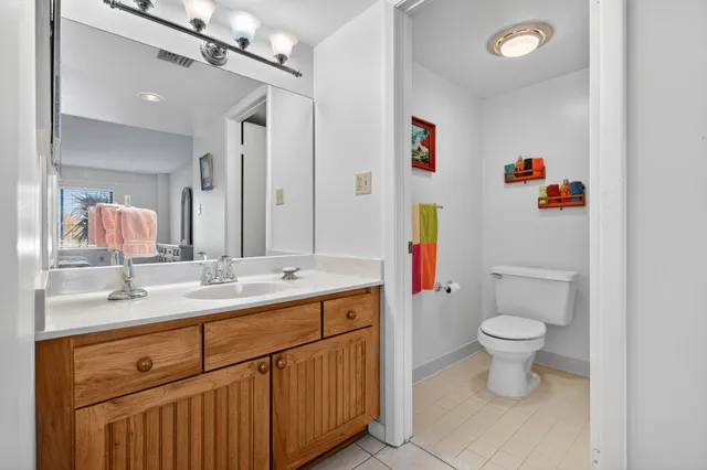 a bathroom with a sink vanity mirror and toilet