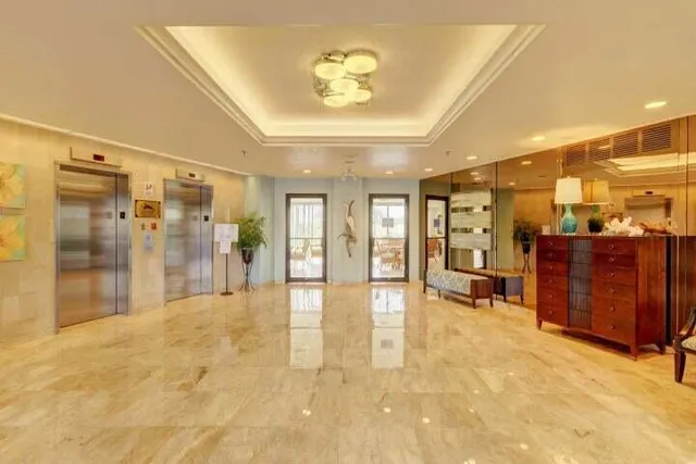a view of a hallway with furniture and a ceiling fan