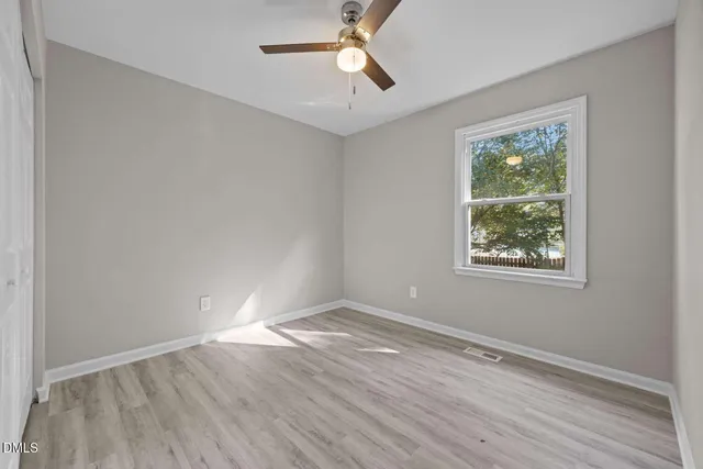 wooden floor in an empty room with a window