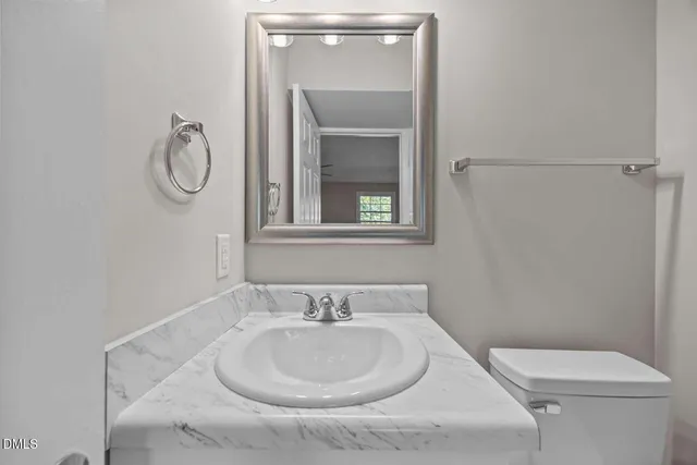 a white toilet sitting next to a bathroom sink