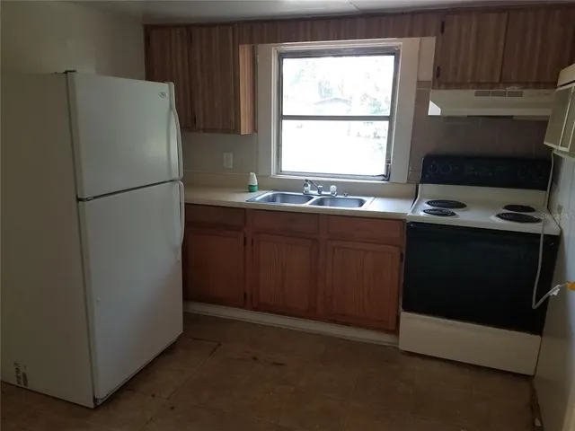 a kitchen with a refrigerator sink and cabinets