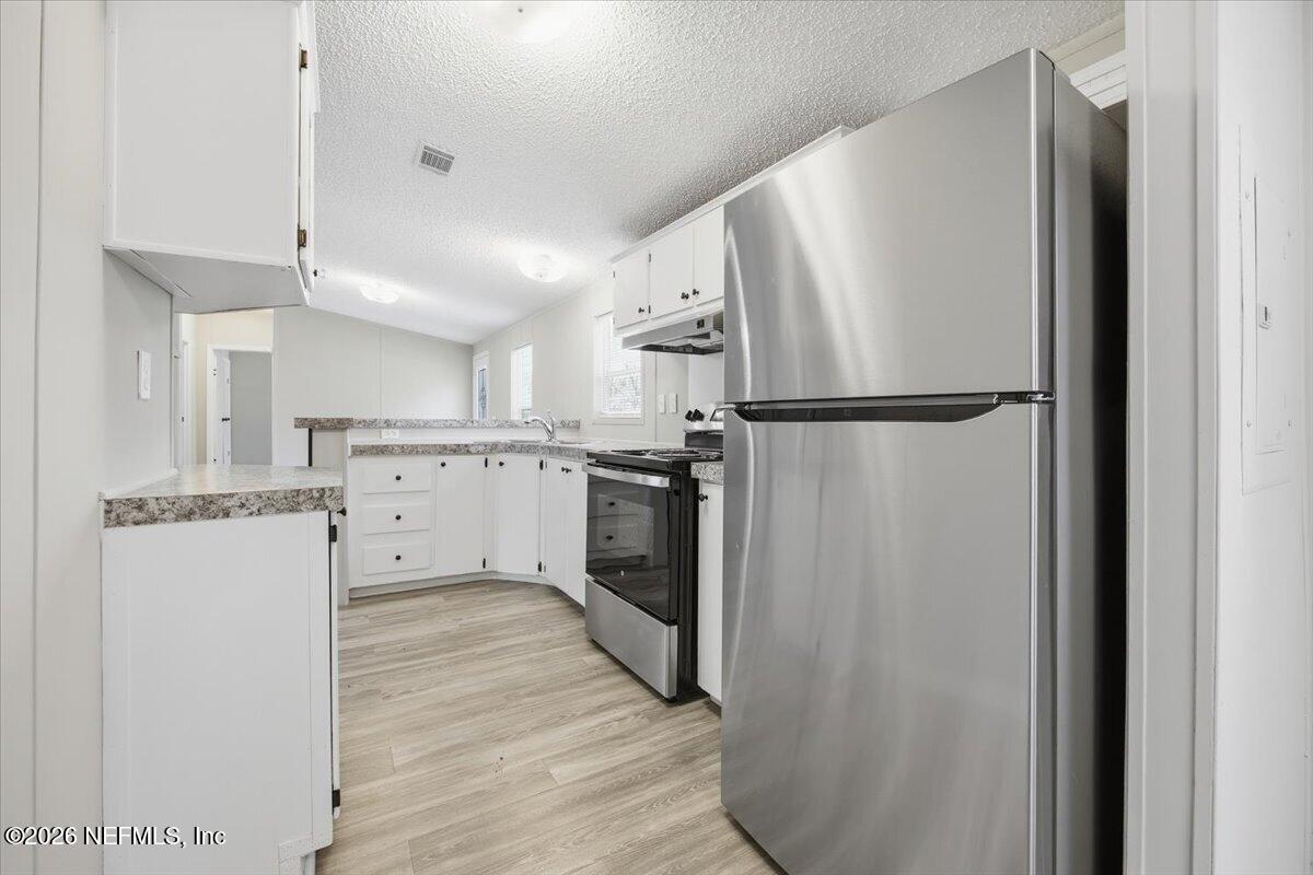 5621 Willow Road Macclenny, FL 32063 - Photo 5 of 15 a kitchen with white cabinets and white stainless steel appliances