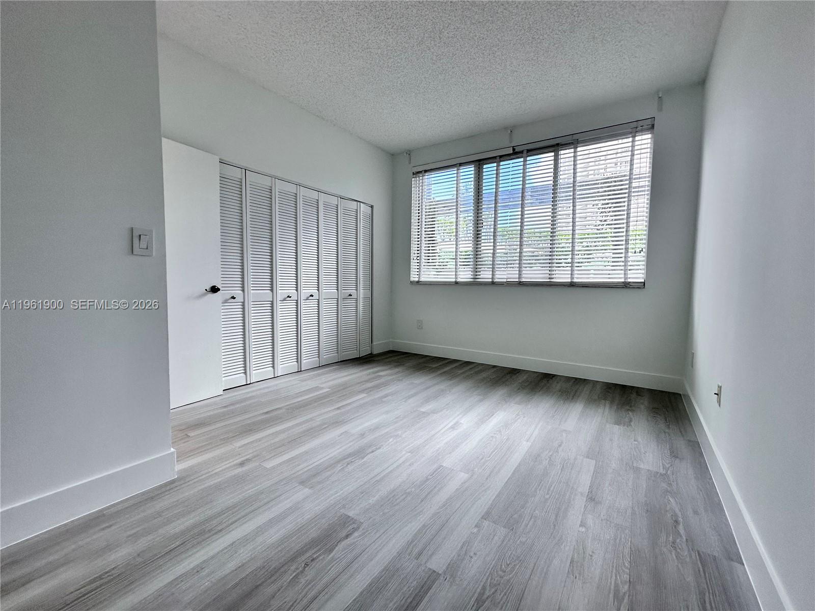 540 Brickell Key Drive, Unit 302 Miami, FL 33131 - Photo 11 of 24 a view of an empty room with wooden floor and a window
