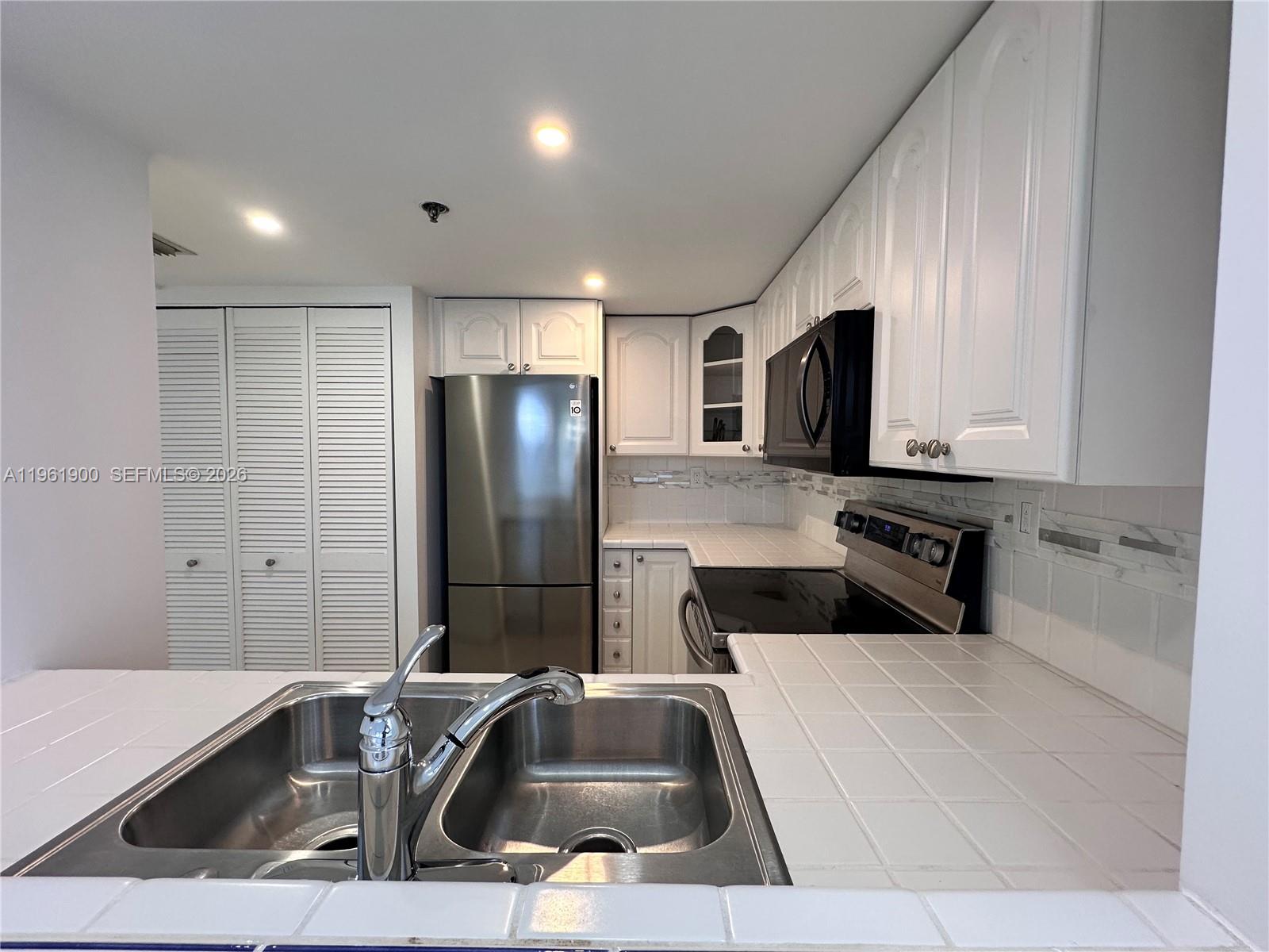 540 Brickell Key Drive, Unit 302 Miami, FL 33131 - Photo 4 of 24 a kitchen with a sink and a refrigerator