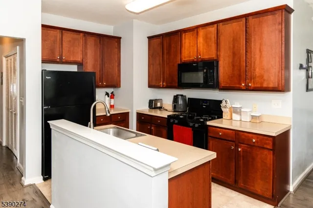 a kitchen with a sink stove top oven and refrigerator