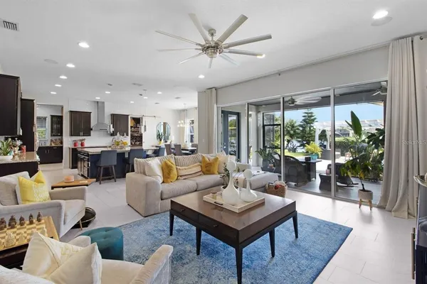 a living room with furniture ceiling fan and a large window