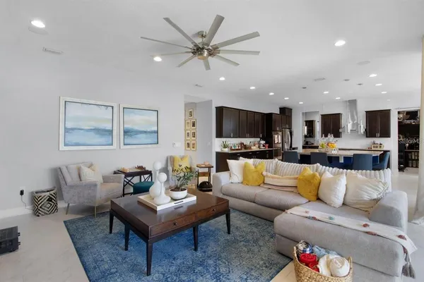 a living room with furniture a flat screen tv and floor to ceiling windows