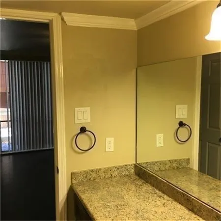 a bathroom with a granite countertop sink and vanity