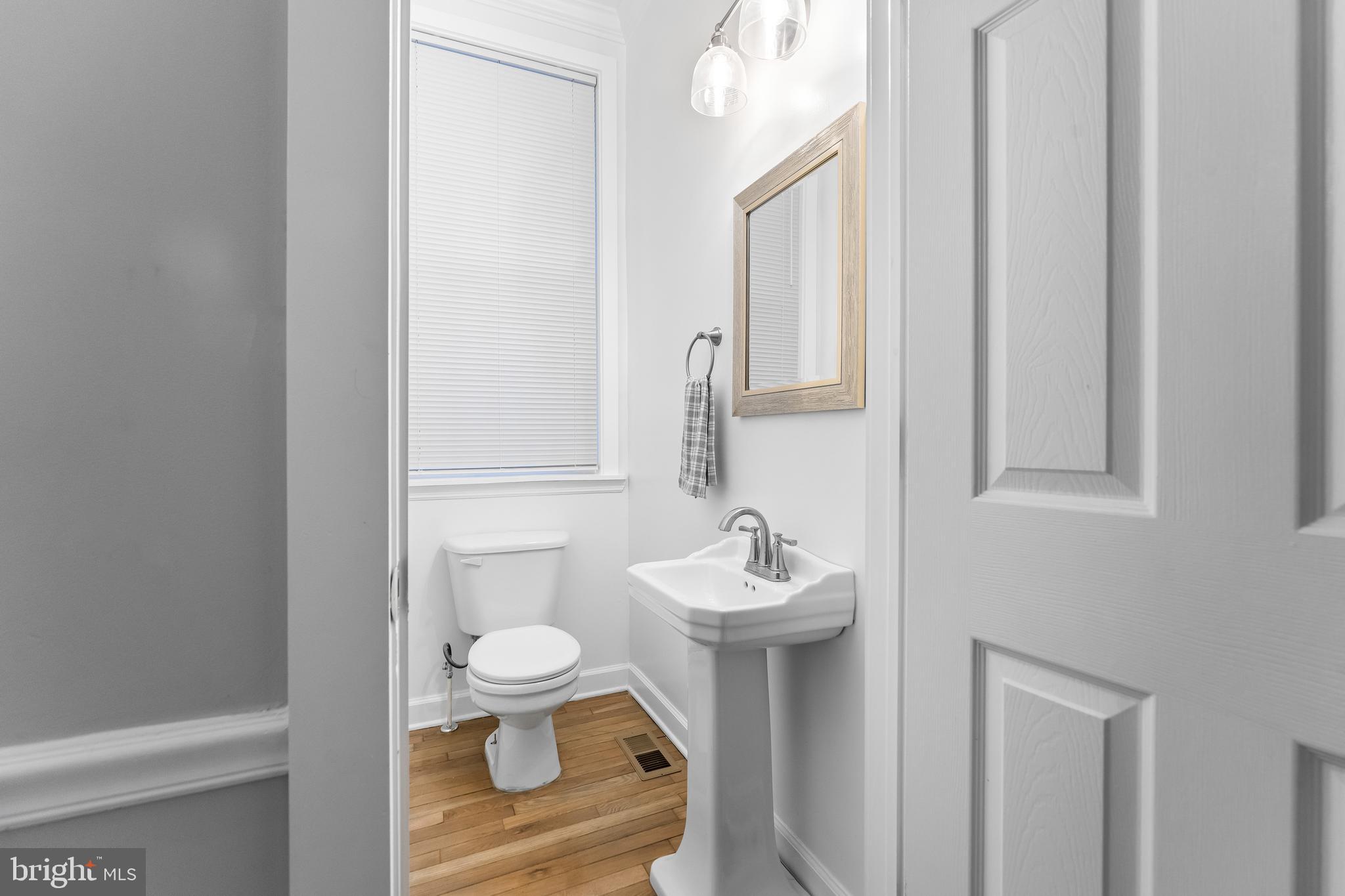1003 West Fayette Street Baltimore, MD 21223 - Photo 13 of 59 a bathroom with a toilet sink and mirror