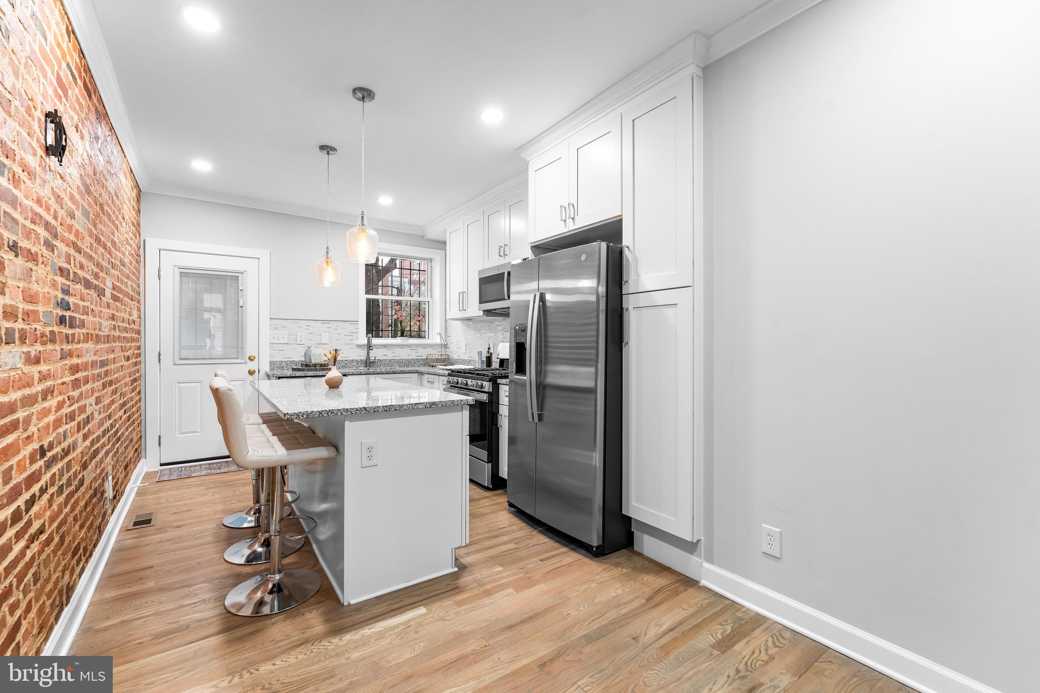 1003 West Fayette Street Baltimore, MD 21223 - Photo 17 of 59 a kitchen with a refrigerator a sink and a dining table