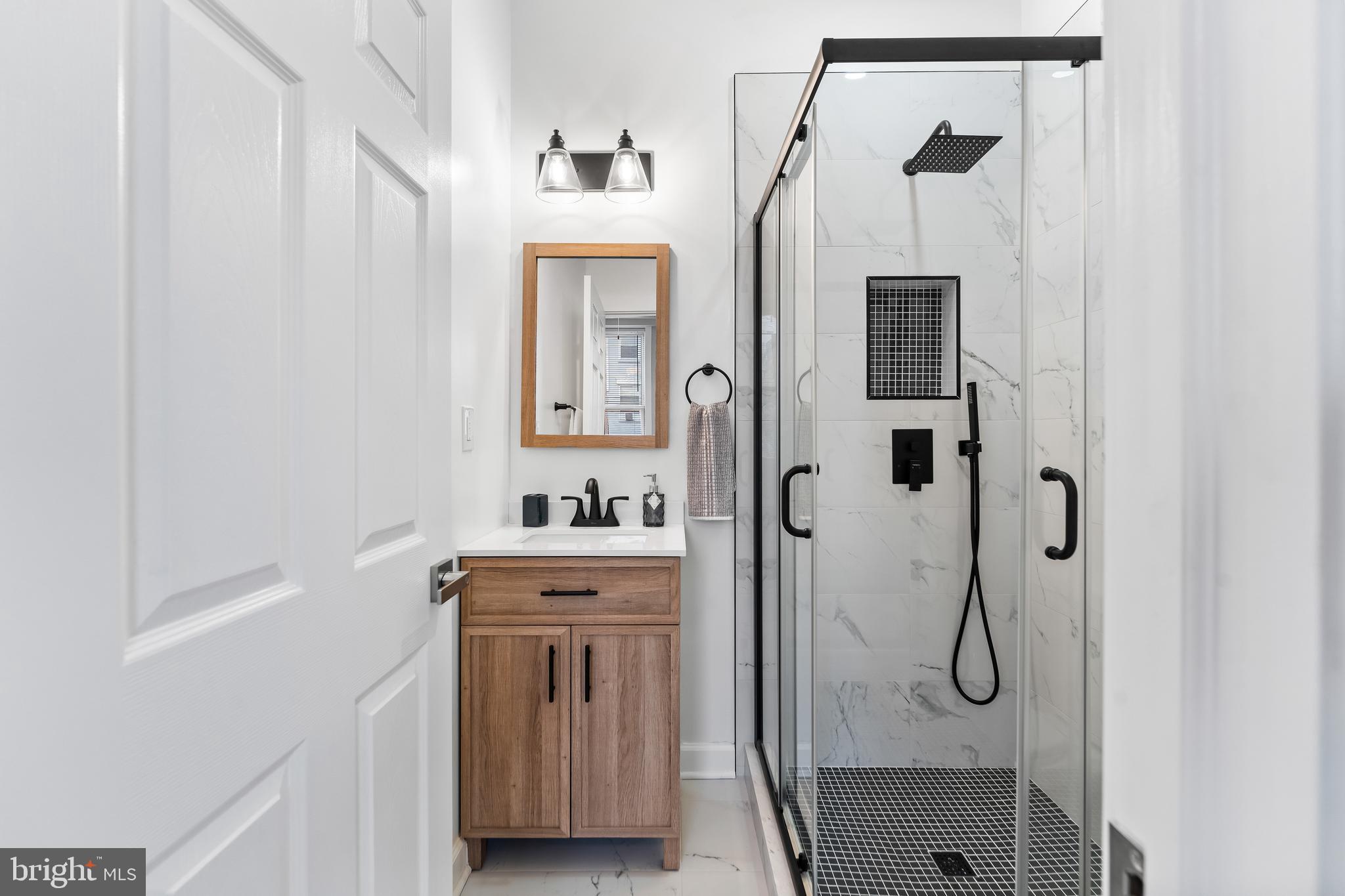 1003 West Fayette Street Baltimore, MD 21223 - Photo 21 of 59 a bathroom with a shower sink and mirror