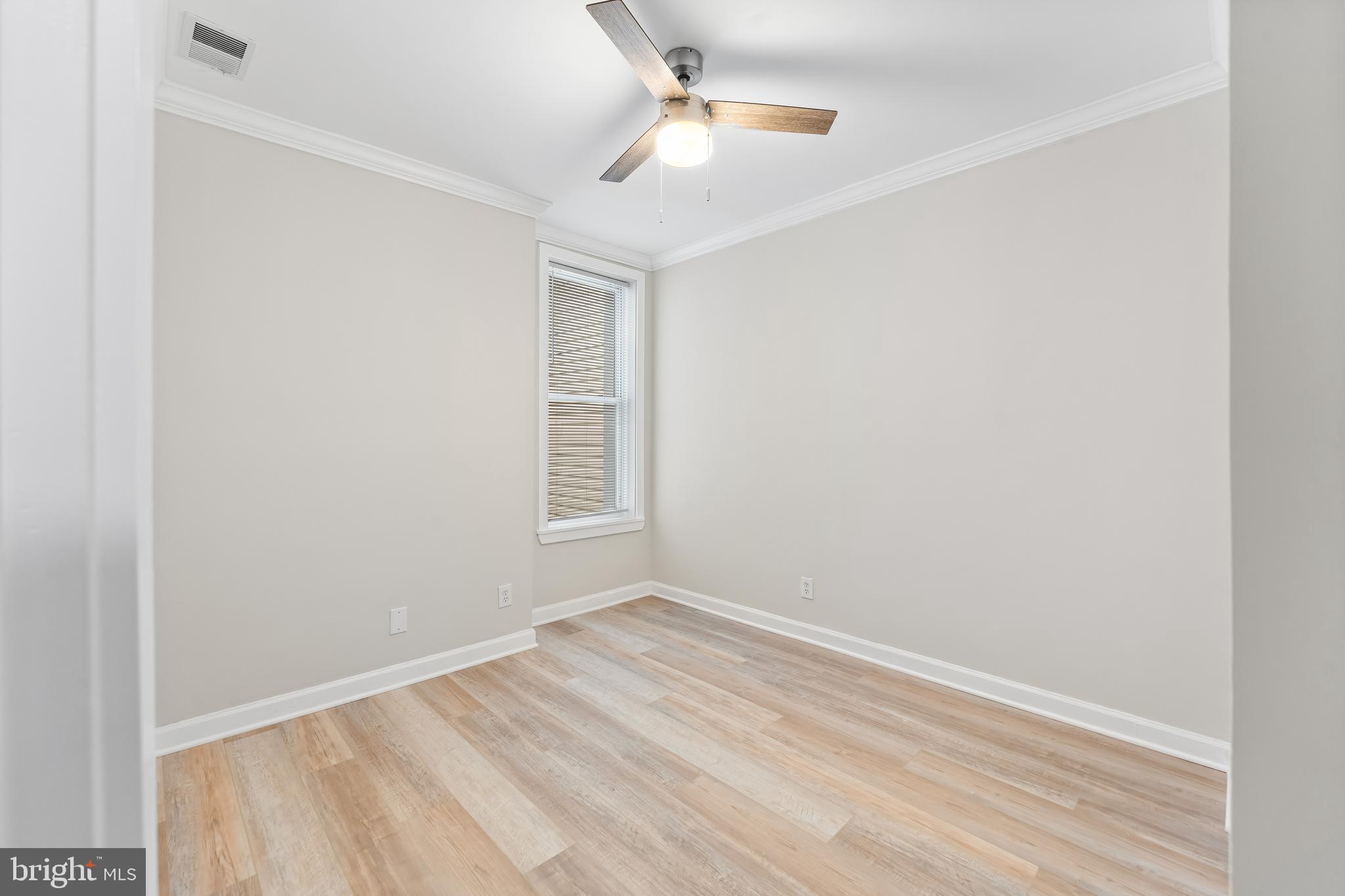 1003 West Fayette Street Baltimore, MD 21223 - Photo 22 of 59 an empty room with windows and ceiling fan