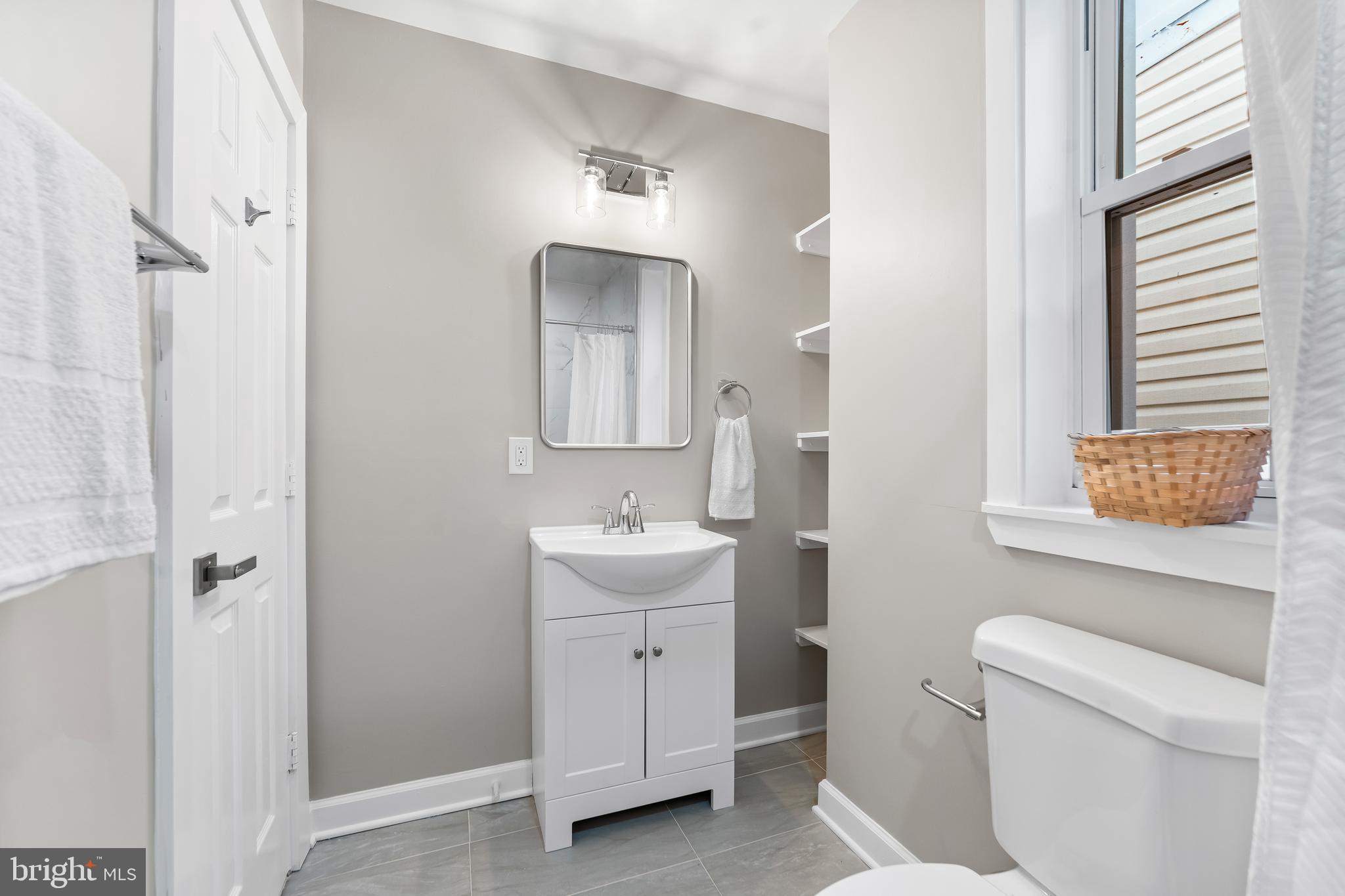 1003 West Fayette Street Baltimore, MD 21223 - Photo 24 of 59 a bathroom with a toilet sink and mirror