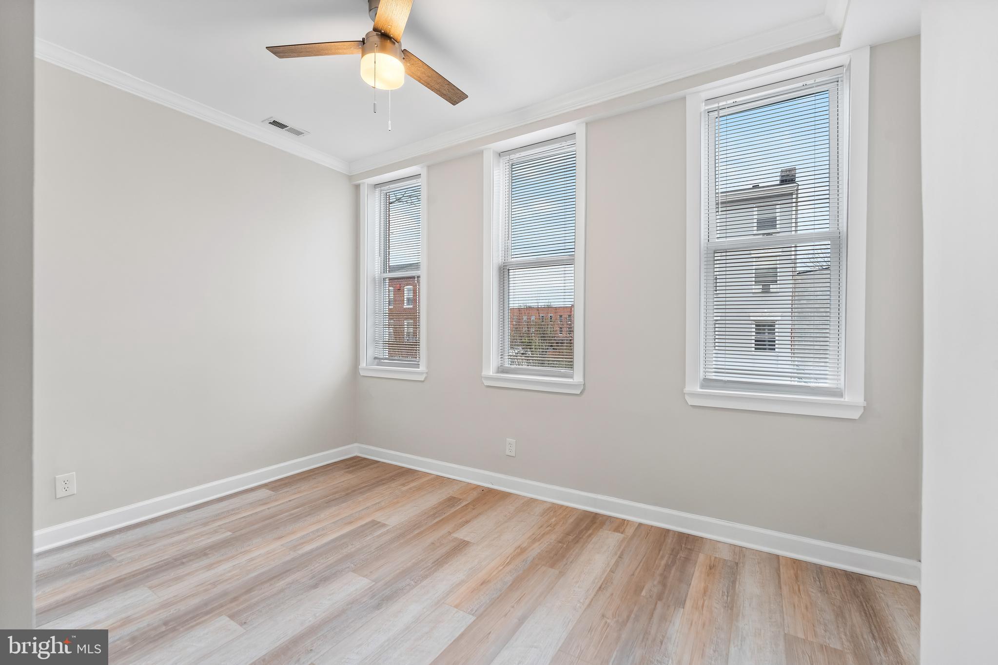 1003 West Fayette Street Baltimore, MD 21223 - Photo 38 of 59 a view of empty room with wooden floor and fan
