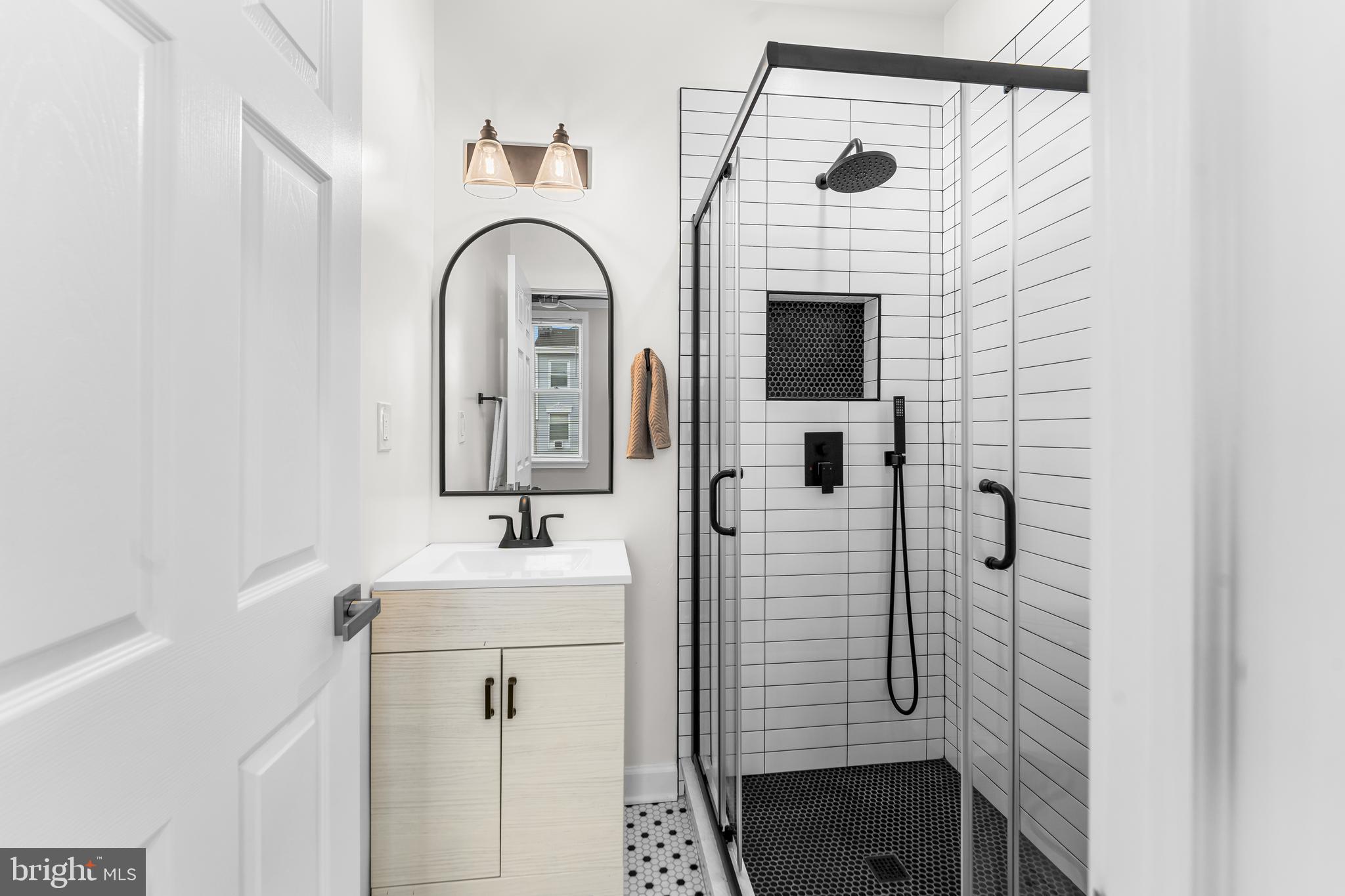 1003 West Fayette Street Baltimore, MD 21223 - Photo 50 of 59 a bathroom with a sink a mirror and shower