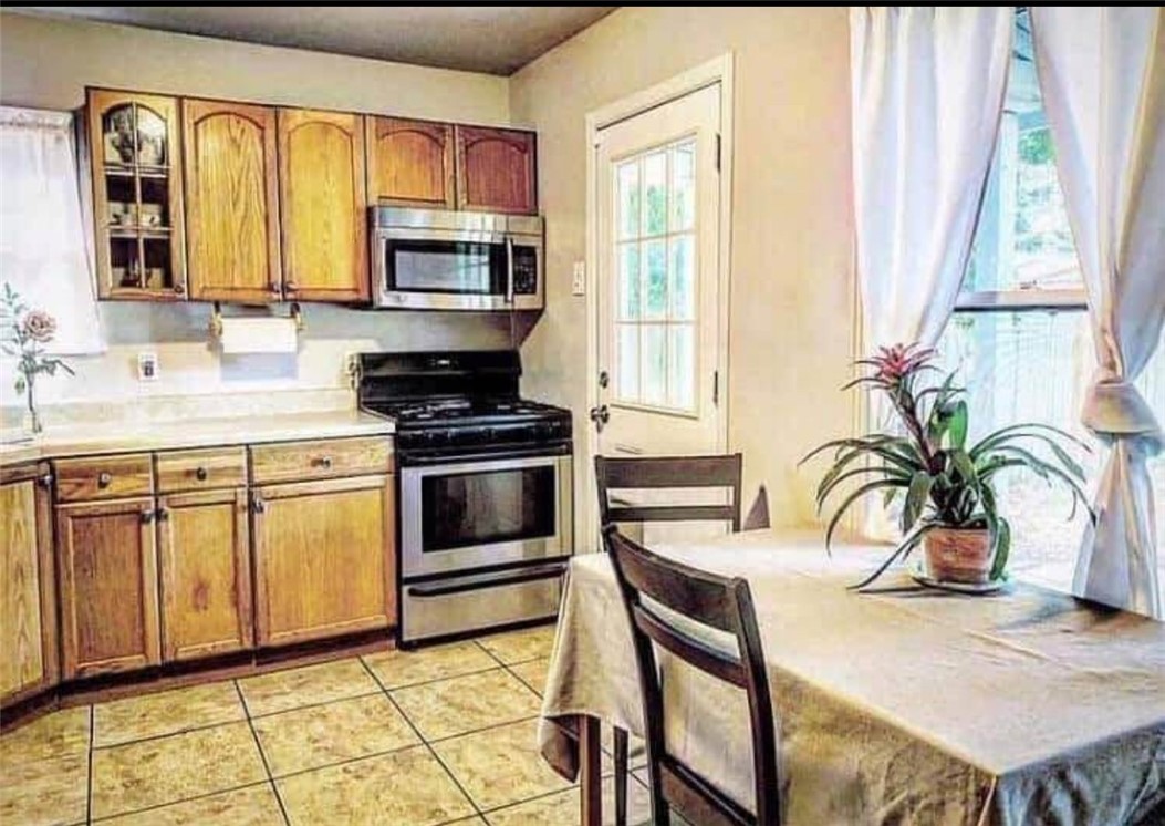 a kitchen with stainless steel appliances granite countertop a stove a sink and a microwave