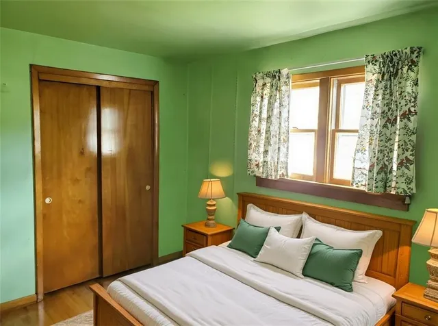 a bedroom with a bed and wooden floor