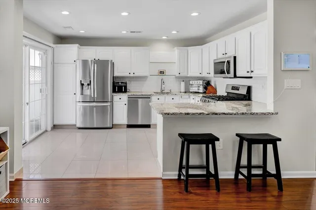 a kitchen with stainless steel appliances granite countertop a refrigerator microwave stove top oven and sink