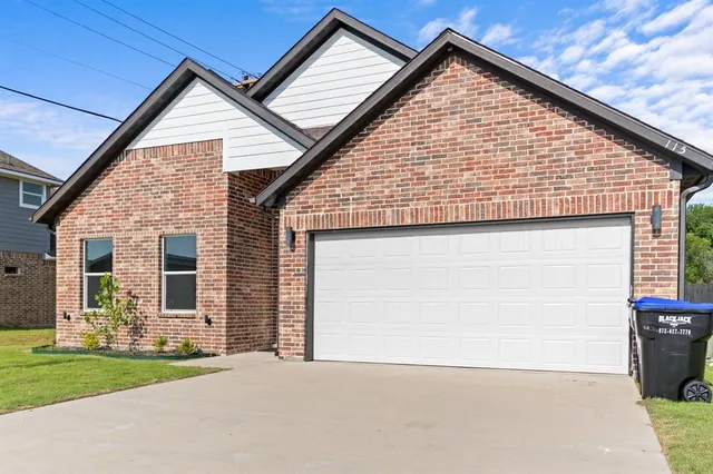 a view of house with yard garage and wooden fence