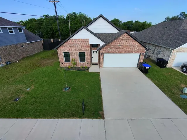 a aerial view of a house next to a yard