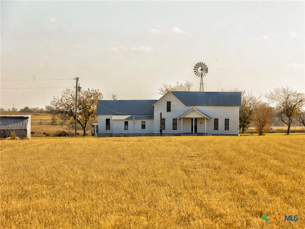 a front view of house with yard and trees in the background
