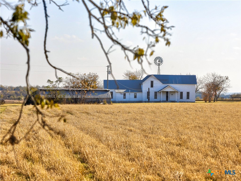 a front view of house with yard and ocean