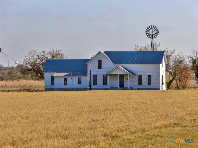 a front view of house with yard and trees in the background