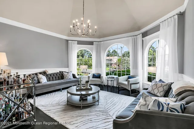 a living room with furniture a mirror and a wooden floor