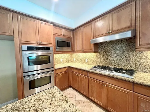 a kitchen with granite countertop a sink stainless steel appliances and cabinets
