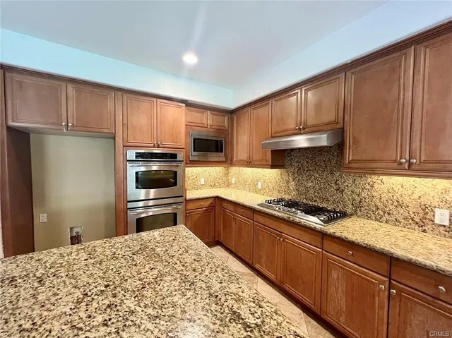 a kitchen with stainless steel appliances granite countertop a refrigerator sink and cabinets