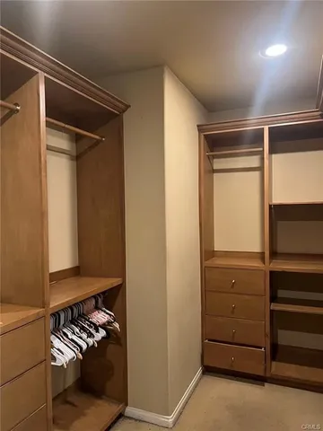 a view of walk in closet with clothes