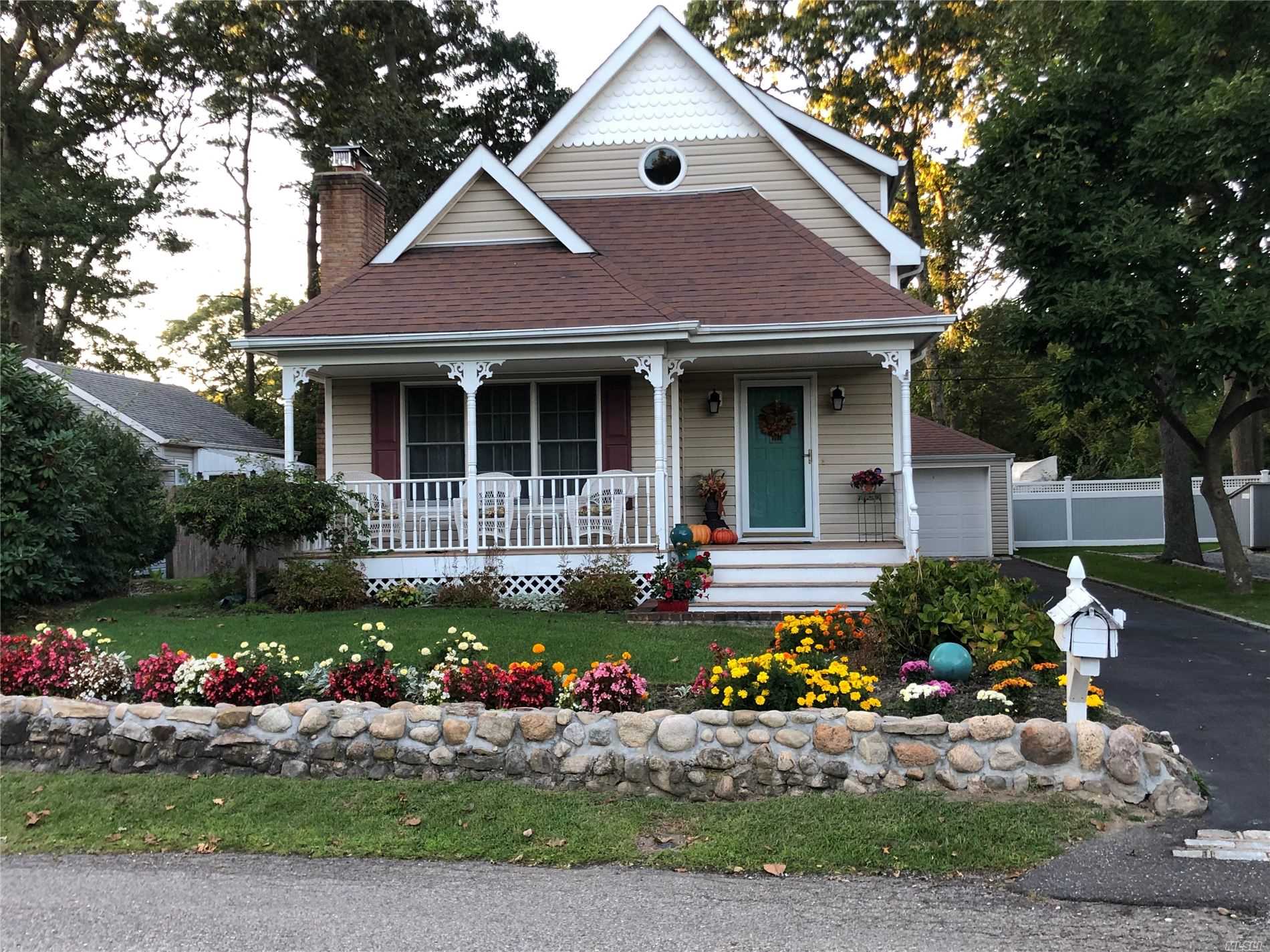 a front view of a house with a yard and a garden