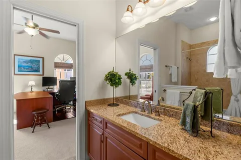 a bathroom with a granite countertop sink a large mirror and shower