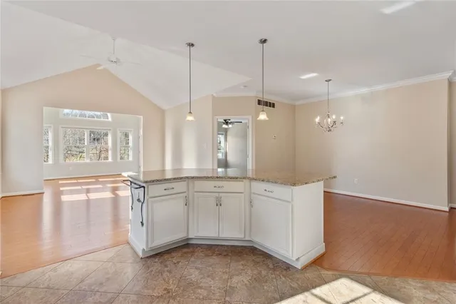 a large white kitchen with a sink a window and stainless steel appliances