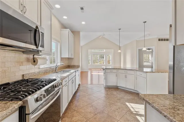 a large kitchen with stainless steel appliances granite countertop a stove and a sink