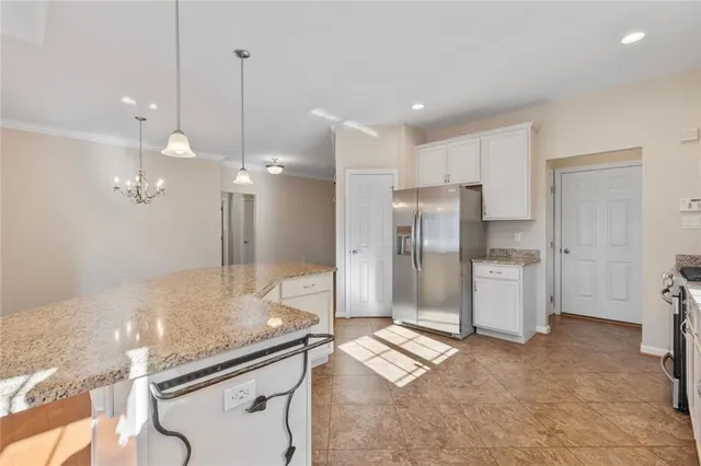 a bathroom with a granite countertop sink a refrigerator and a shower