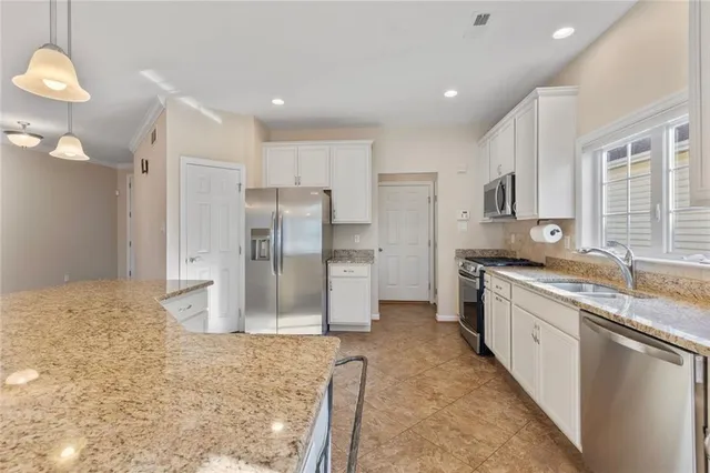 a kitchen with stainless steel appliances granite countertop a refrigerator and a sink