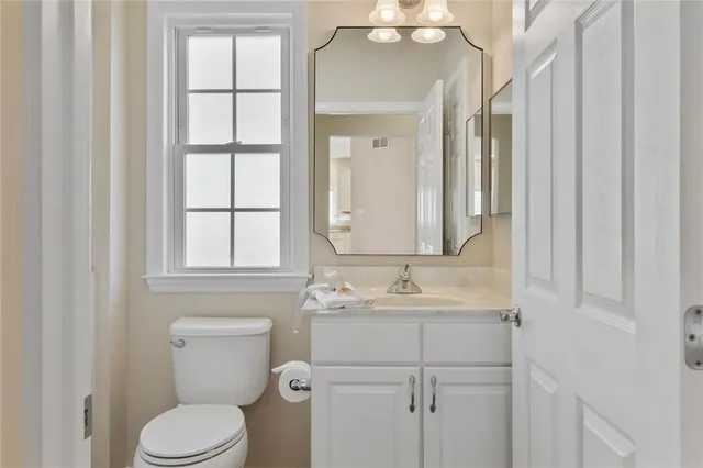 a bathroom with a toilet sink and mirror