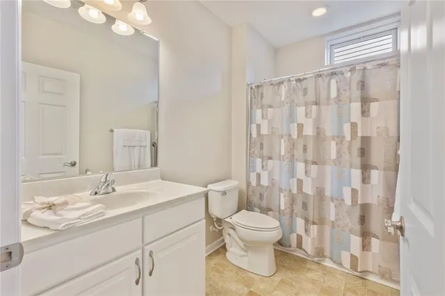 a bathroom with a sink a toilet and shower curtain