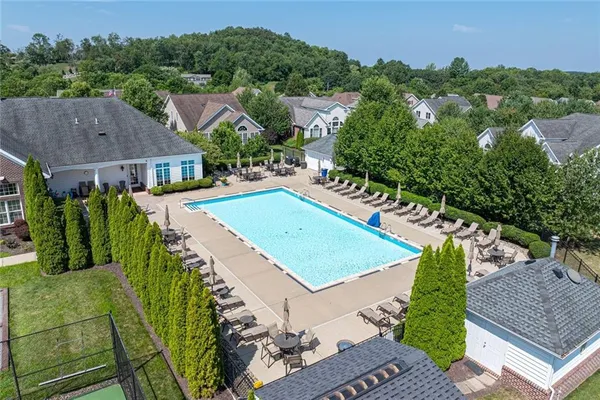 an aerial view of residential houses with outdoor space and trees