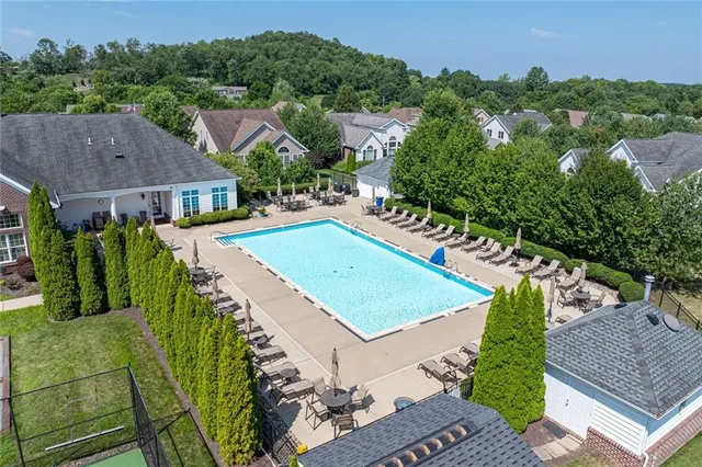 an aerial view of residential houses with outdoor space and trees
