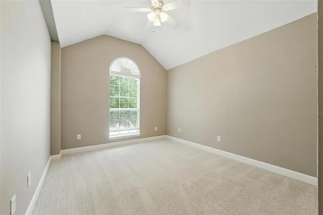 an empty room with windows and chandelier fan