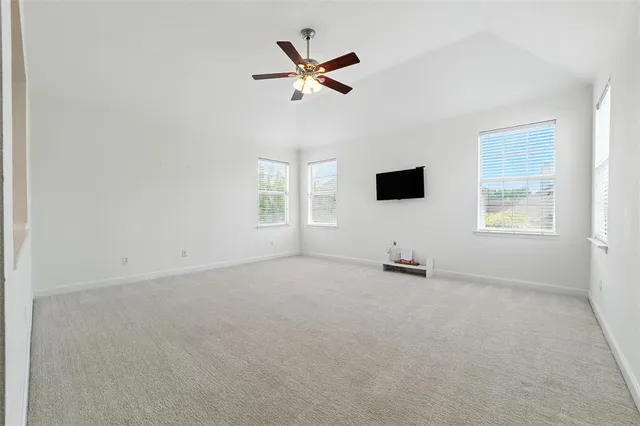 an empty room with windows and ceiling fan view