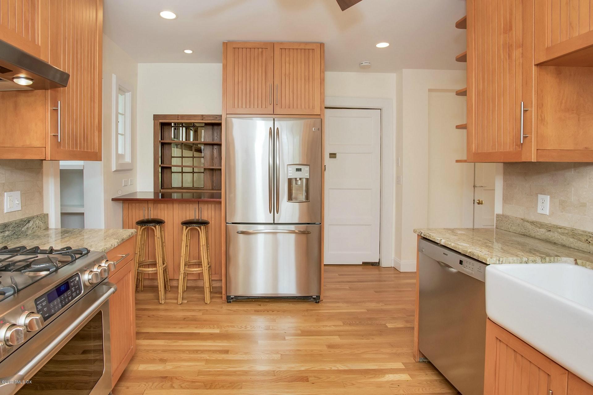 17 Ballwood Road Old Greenwich, CT 06870 - Photo 13 of 36 a kitchen with stainless steel appliances granite countertop a refrigerator a stove and a sink with wooden floor